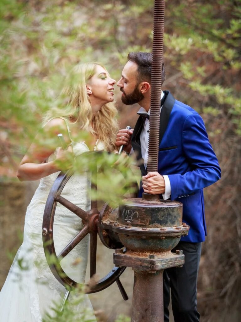 Το ζευγάρι δίπλα σε παραδοσιακό ξύλινο τροχό σε εξωτερικό χώρο στη Ρόδο